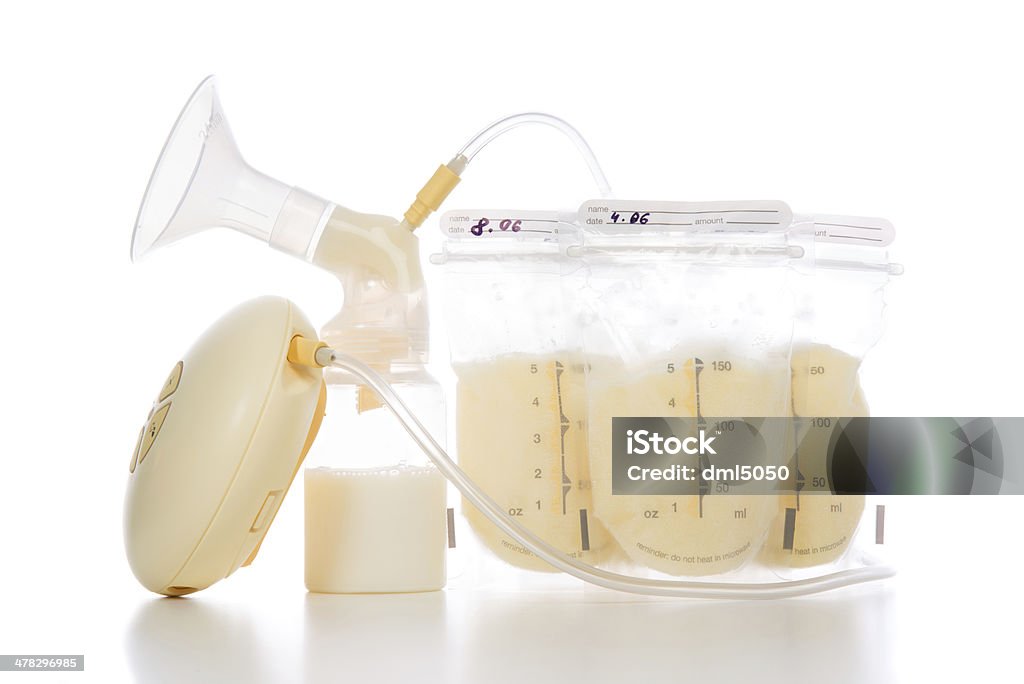 breast pump and bags of frozen breastmilk New compact electric breast pump to increase milk supply for breastfeeding mother and bags of frozen breastmilk on white background Breast Pump Stock Photo