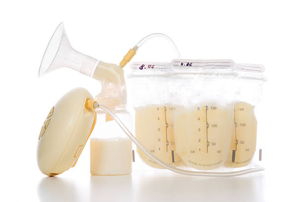 breast pump and bags of frozen breastmilk stock photo