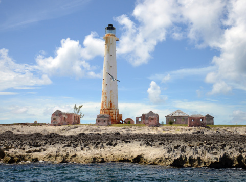 Abandoned lighthouse in the Bahamas surrounded by empty houses