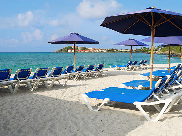 istock Beach scene with blue lounge chairs and umbrellas 478300129