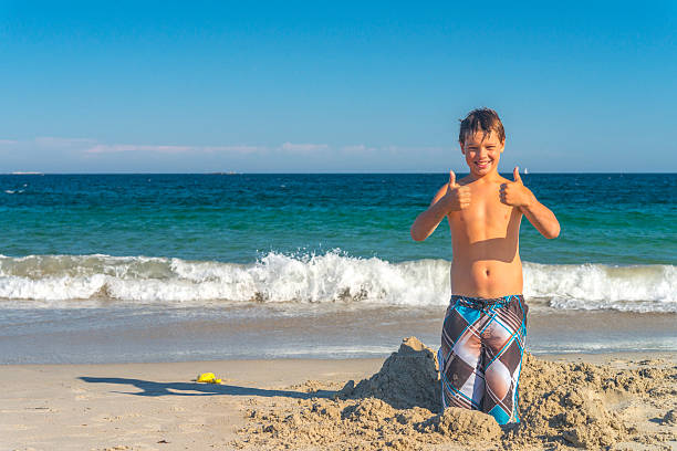 istock Boy with thumbs up at beach 478301199