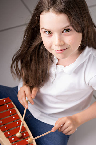 istock Cute dark haired girl playing Xylophone 478303785