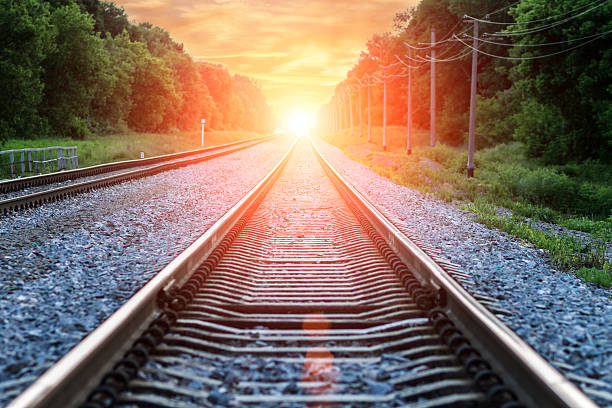 istock Straight Railroad into orange sunset with clouds in sky 478305548