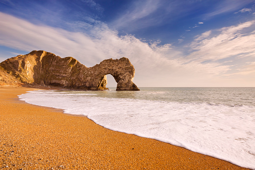 The Durdle Door rock arch on the Dorset Coast in Southern England on a sunny day.