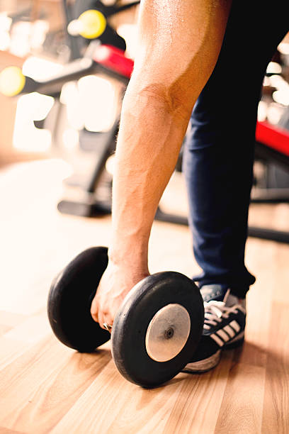 istock Muscular man exercising on dumbbell in gym 478306932