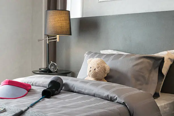 Photo of kids room with doll and pillows on bed at home