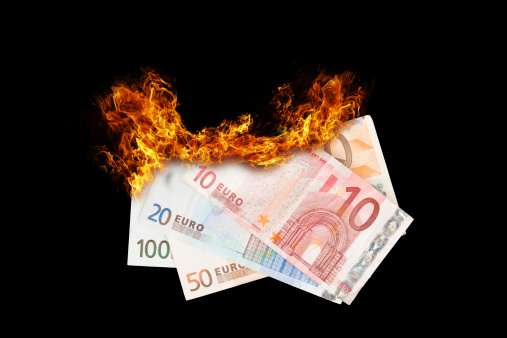 Burning money, euro bills on fire, isolated on black