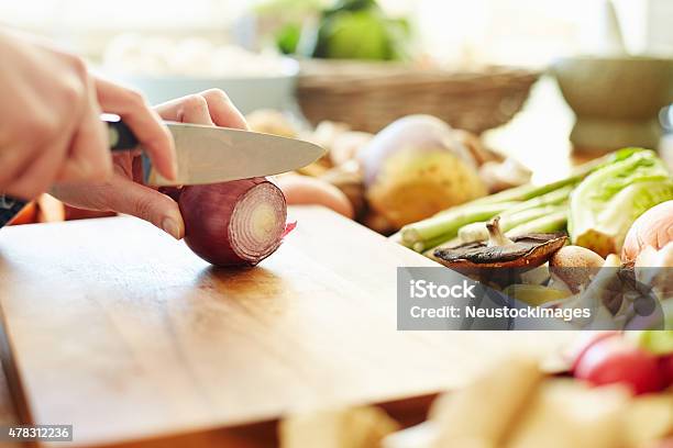 Cropped Image Of Woman Cutting Onion At Table Stock Photo - Download Image Now - 2015, Adult, Adults Only