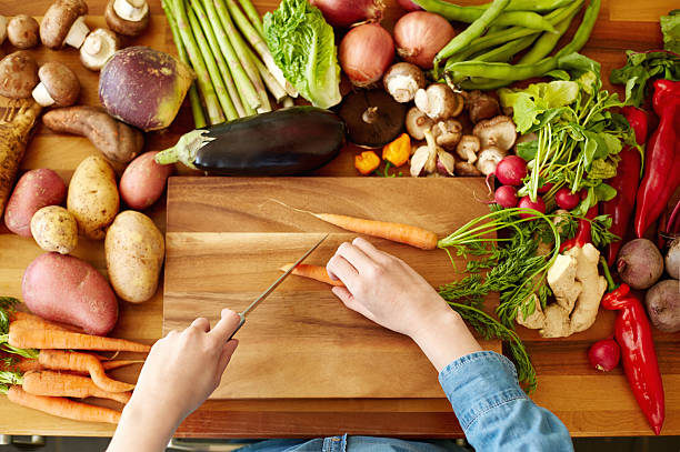 istock Woman cutting carrots by various vegetables 478312258