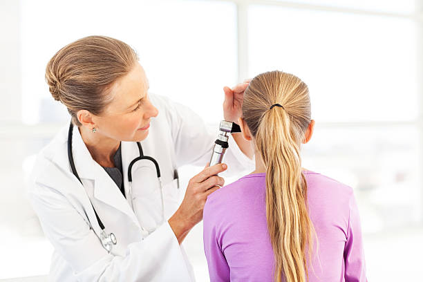 doctor examinar chica en la oreja con otoscopio - otoscopio fotografías e imágenes de stock