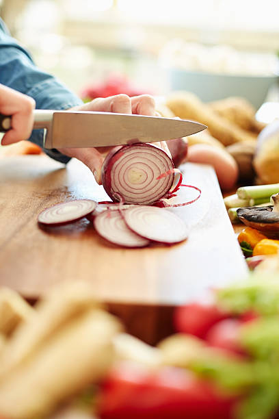 istock Cropped image of female hands chopping onion 478312352
