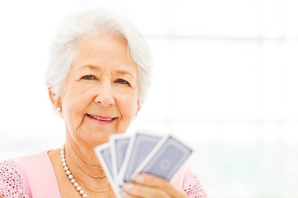 istock Smiling Senior Woman Holding Playing Cards 478312554