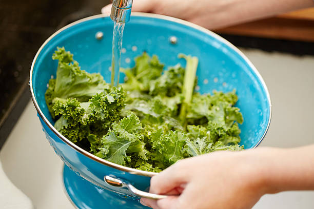 istock Woman washing kale in colander at kitchen 478312560