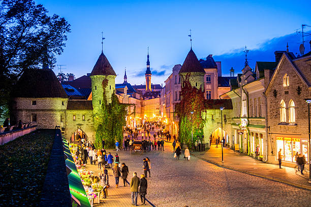 Tallinn, Estonia - October 11, 2014: Tallinn, Estonia City view including towers that form part of the historical city fortifications at the gateway to the historical district  with people at a market in the street