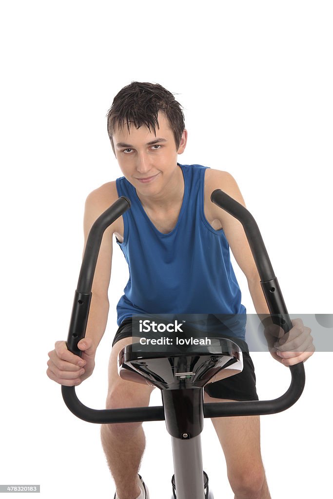 Ragazzo adolescente utilizzando una cyclette fitness - Foto stock royalty-free di Abbigliamento sportivo
