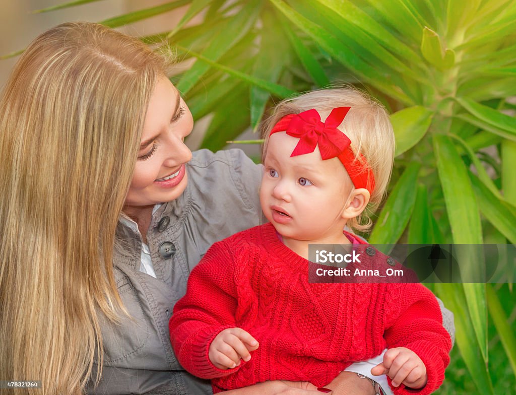 Happy family in the park Portrait of beautiful blond female with her little daughter having fun in the park, enjoying motherhood, love and happiness concept 2015 Stock Photo
