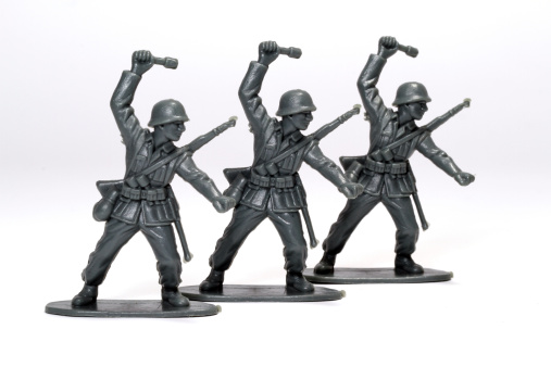 Three toy soldiers throwing grenades.