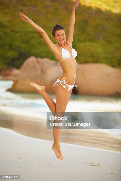 Happy Young Woman Jumping While Enjoying On Beach 관능에 대한 스톡 사진 및 기타 이미지 - 관능, 긍정적인 감정 표현, 나이