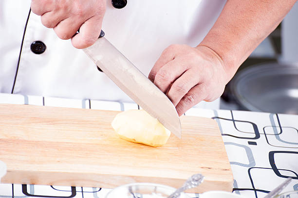 istock Chef cutting Potato on wooden broad 478326054