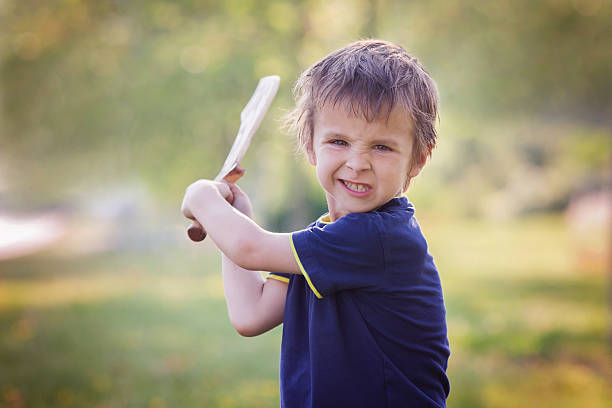 istock Angry little boy, holding sword, glaring with a mad face 478330096