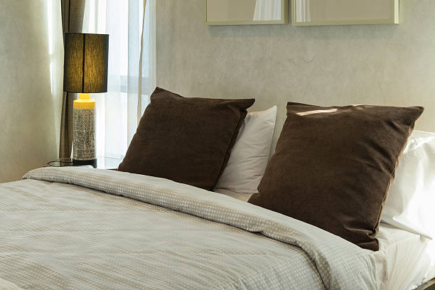 istock brown pillows on bed with lamp 478330860