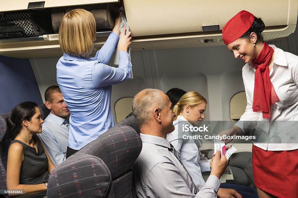 Assistente di volo aereo biglietto aereo cabina sorridente controllo - Foto stock royalty-free di Personale di volo
