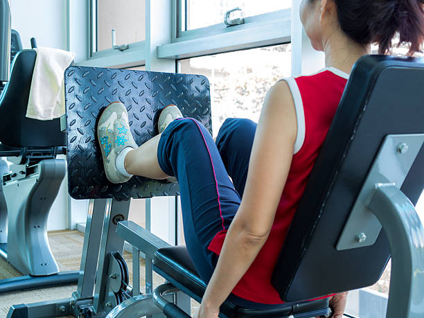 istock Woman exercising with machine in gym 478336428