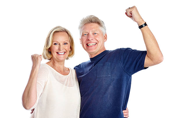 mature caucasien couple joie de succès - arms outstretched arms raised studio shot adult photos et images de collection