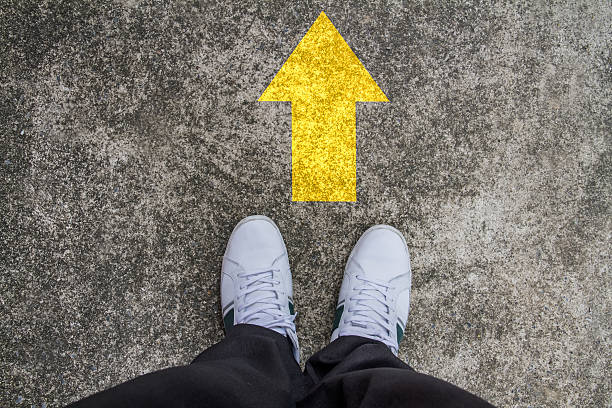 istock standing on a tarmac road with yellow arrow print 478337455