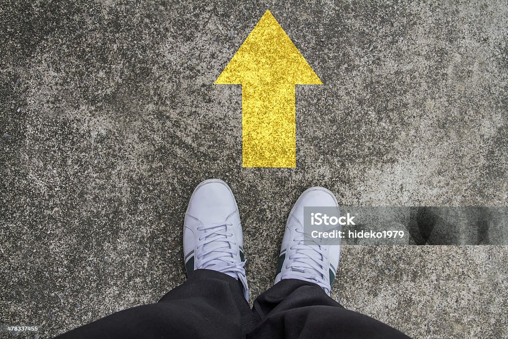 standing on a tarmac road with yellow arrow print Achievement Stock Photo