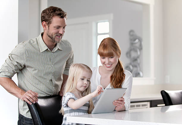 istock Family of three looking at a digital tablet 478338619
