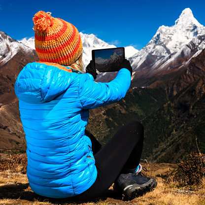 Young woman taking picture in Himalayas using a tablet, Mount Ama Dablam on background. Mount Everest National Park. This is the highest national park in the world, with the entire park located above 3,000 m ( 9,700 ft). This park includes three peaks higher than 8,000 m, including Mt Everest. Therefore, most of the park area is very rugged and steep, with its terrain cut by deep rivers and glaciers. Unlike other parks in the plain areas, this park can be divided into four climate zones because of the rising altitude. The climatic zones include a forested lower zone, a zone of alpine scrub, the upper alpine zone which includes upper limit of vegetation growth, and the Arctic zone where no plants can grow. The types of plants and animals that are found in the park depend on the altitude.http://bem.2be.pl/IS/nepal_380.jpg