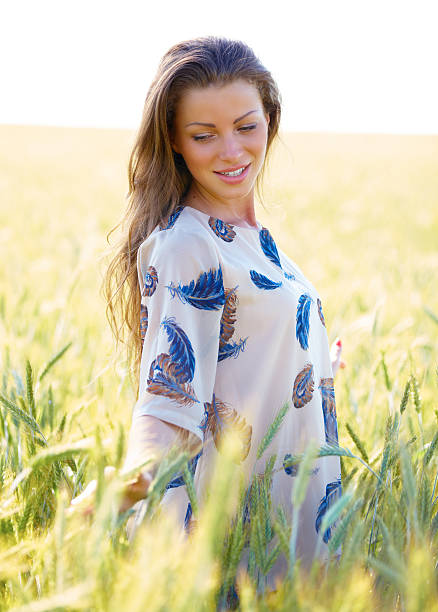 istock beautiful young brunette woman on wheat field 478350131