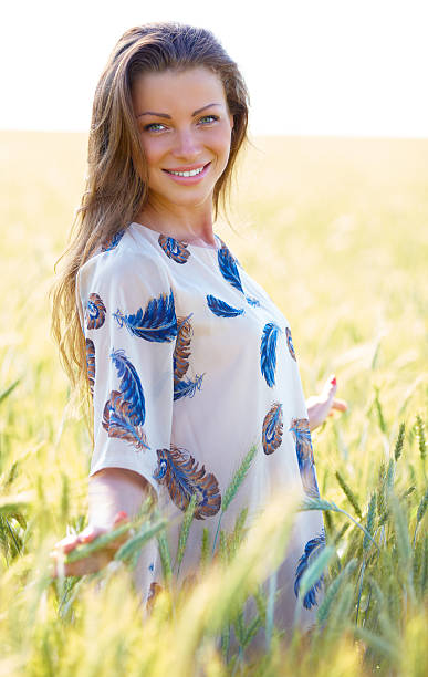 istock beautiful young brunette woman on wheat field 478350191