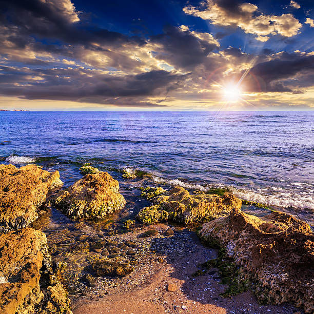istock sea wave breaks about boulders at sunset 478350453