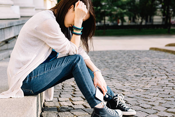 ein deprimierter mädchen sitzt an der straße - obscured face fotos stock-fotos und bilder