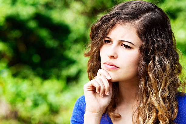 istock Thoughtful young curly-haired beauty in garden considers things 478353042