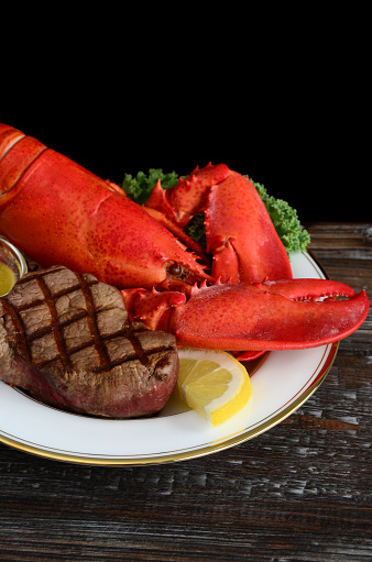 Surf and turf dinner - freshly boiled whole New England lobster and grilled filet mignon steak with melted butter.