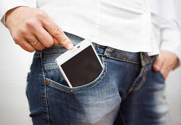 istock woman pushing big mobile phone in jeans pocket 478357836