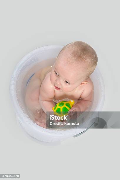 Cute Baby In Transparent Bucket And Playing With Toys Stock Photo - Download Image Now