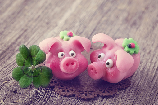 Marzipan pigs on wooden background