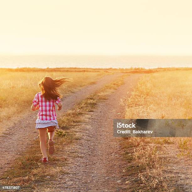 Little Girl Running In Backlit Meadow Stock Photo - Download Image Now - Back Lit, Rear View, Activity