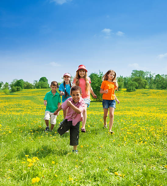 piccoli ragazzi e ragazze in esecuzione - child playing running group of people foto e immagini stock