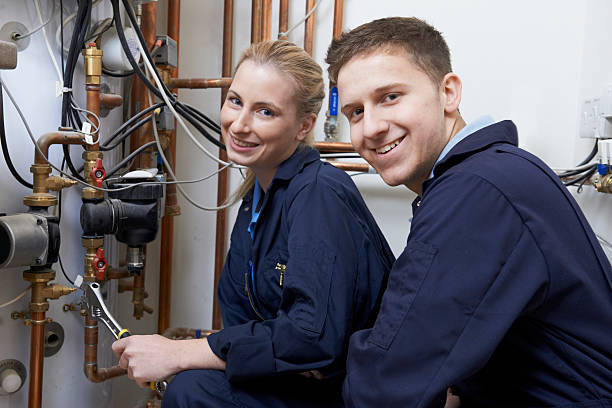 istock Female Trainee Plumber Working On Central Heating Boiler 478373024