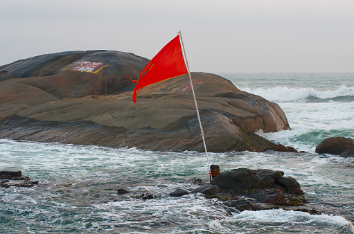 A red flag warning of danger of windy and seawaves on the beach during monsoon season.