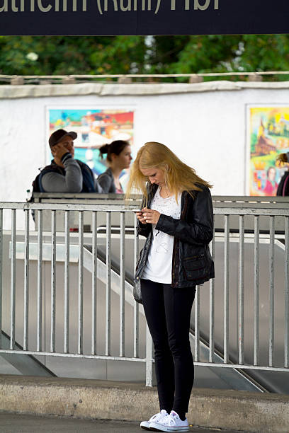 mulher loira caucasiana com celular na plataforma - smart phone iphone women mobile phone - fotografias e filmes do acervo