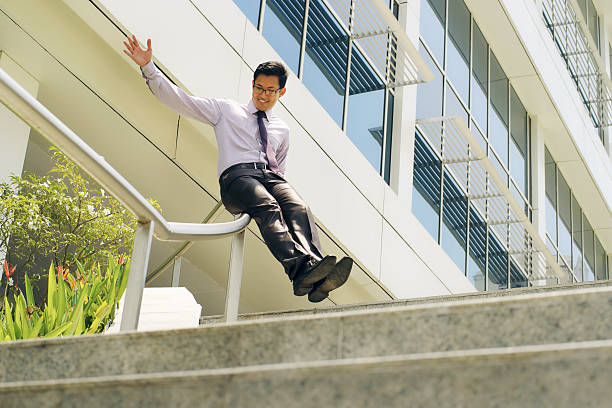 istock Chinese Businessman Going Downstairs Sliding On Rail For Joy 478381494