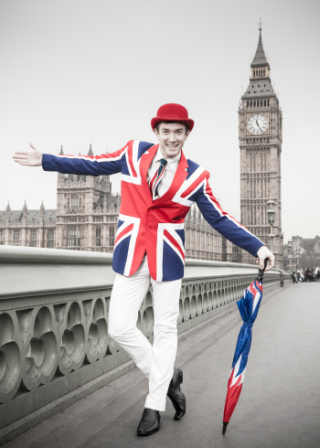 British man dressed in Union Jack jacket, tie with umbrella. Red, white and blue.