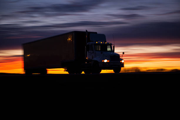 Tractor trailer on highway at sunset. stock photo
