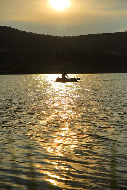 istock Fisherman on a boat at sunset 478393424